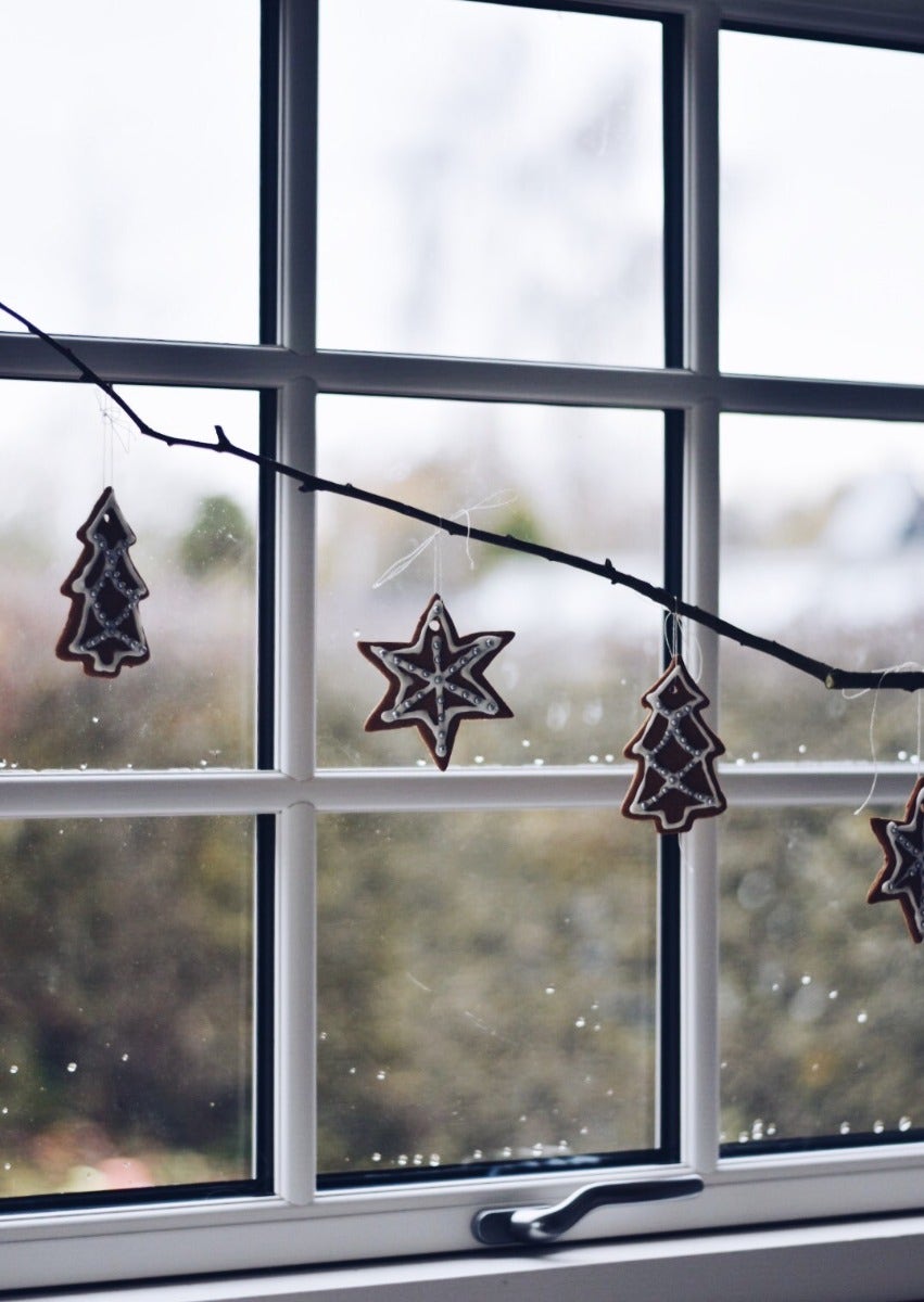 Kerstversiering bij raam met roeden